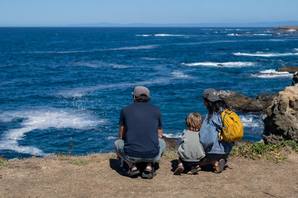 A family of three sitting at the edge
