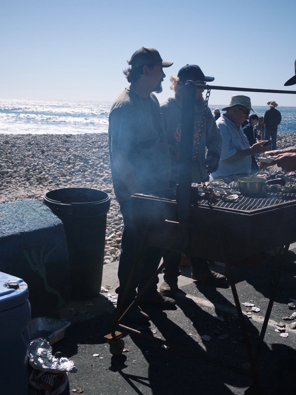 Two figures in cowboy hats, backlit by the grill