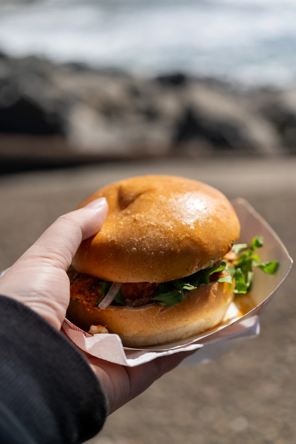The burger, held in one hand
