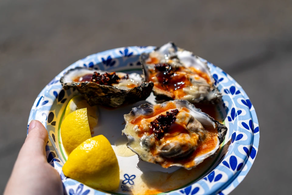 Grilled oysters and lemon on a blue-and-white plate
