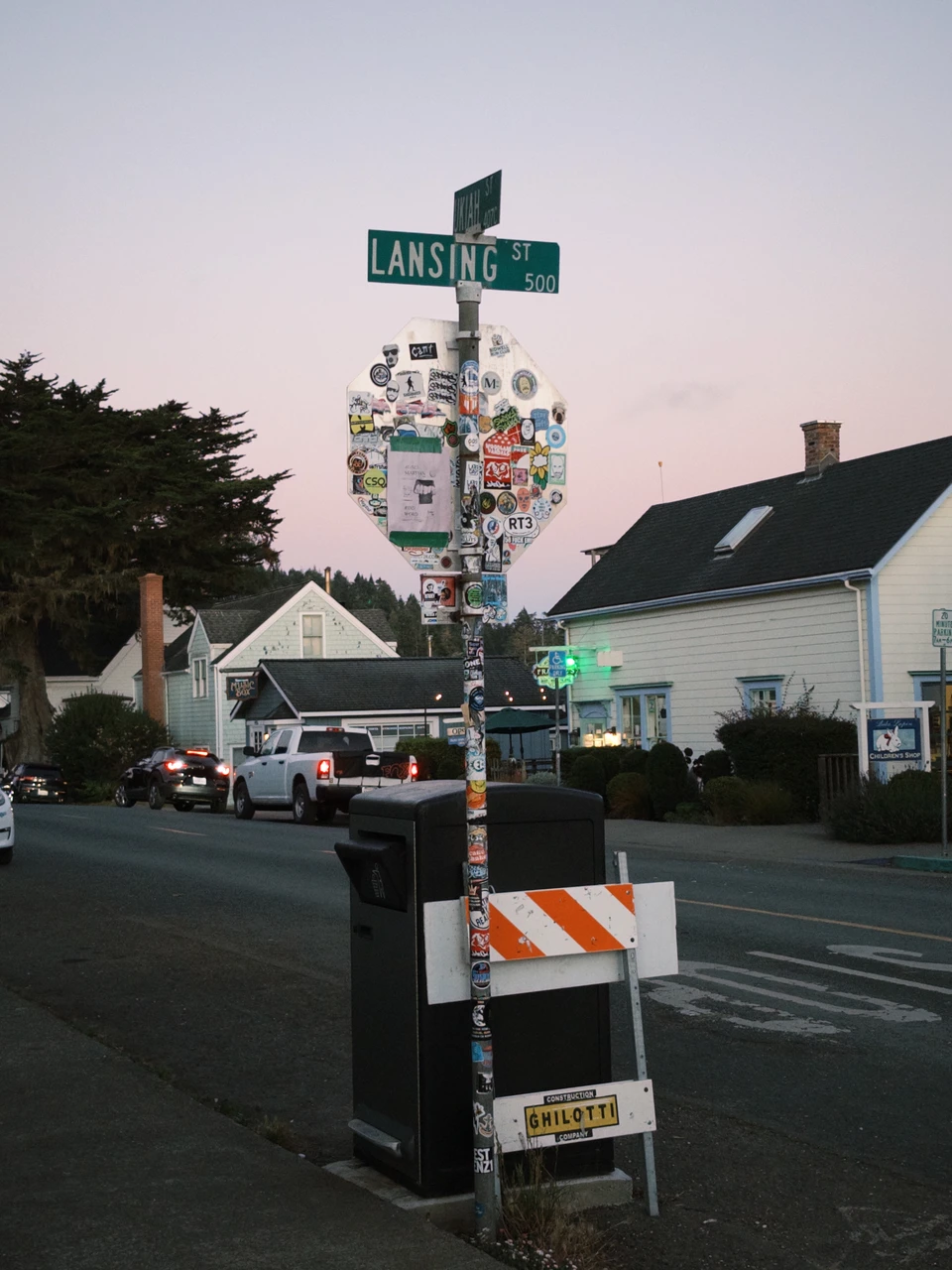 A street corner post covered in signs